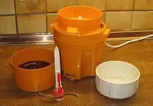 Seitliche Aufnahme einer auseinandergenommenen orangenen Moulinette