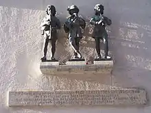 Figurengruppe auf der Nordseite des Karlstores in München ("Die drei Musikanten"), von Konrad Knoll. Die Gruppe war Bestandteil des alten Fischbrunnen der von 1884 bis 1944 am Marienplatz stand.