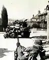 Amerikanische Infanterie sucht Deckung hinter Panzerfahrzeugen