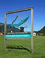 Schild des Zentrums mit Nationalpark-Logo: ein Steinadler vor Gebirgskulisse