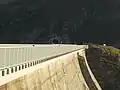 Der Tunnel von 2017 durchquert die Ausläufer der Lobspitzen. Im Vordergrund die Griffe einer Kletterroute an der Hauptstaumauer.
