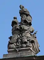 40. Trophäe – Baumstamm, Turban, Harnische mit Helm, Fass, Vasen, Lanzenfahne.