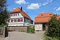 Pfarrgehöft von 1804 mit Fachwerkscheune (seit 1965 Gemeindezentrum „Schwalbennest“)