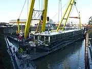 Die gehobene Pure-Liner 2 an den Haken der Schwimmkräne HEBO-Lift 6 und HEBO-Lift 7 und beim Auspumpen.