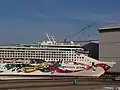 Die Norwegian Jewel im Größenvergleich mit Menschen und einem Toilettenhäuschen