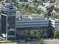 ZEISS Museum der Optik rechts vom Hoch­haus im Erdgeschoss hinter der Glasfront