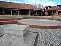 Blick über die Feuerstelle und die Wasserquelle; im Hintergrund der evangelische Teil des Zentrums