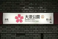 Ōhorikōen, Fukuoka:Stationslogo (japanische Kirschblüte), Vollname in Kanji und Transkriptionen in Hiragana und Rōmaji, englische Übersetzung und Stationsnummer (K06)