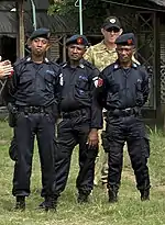Polizisten bei der Ausbildung durch australische Soldatenund Polizeiabzeichen unter der UN-Verwaltung 2001