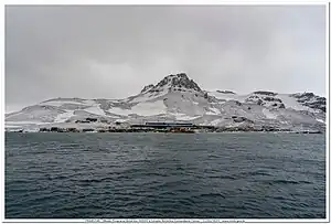 Blick vom Martel Inlet auf die Keller-Halbinsel mit dem oberhalb der brasilianischen Estação Antártica Comandante Ferraz aufragenden Flagstaff Hill und dem rechts des Gipfels befindlichen Flagstaff-Gletscher
