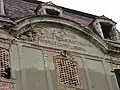 Giebelfeld mit Inschrift am nördlichen Seitenflügel des Schlosses