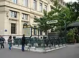 Von Hector Guimard entworfener Jugendstil-Zugang, dahinter das Gebäude des Tribunal de commerce de Paris