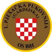 Soldat des 1. Infanterie-(Garde-)Regiments OS BiH (Traditionsregiment HVO) mit seinem Partner von der US-Armee während eines Manövers auf dem Truppenübungsplatz „Eugen Kvaternik“ (2012) und Ärmelabzeichen der Einheit.