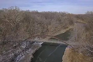 Luftaufnahme der Pathfinder-Parkway-Brücke, eine Hängebrücke für Fußgänger und Radfahrer, die den Caney River überquert