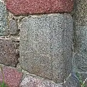 Schachbrettstein am Eingang der Dorfkirche