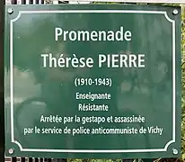 Zu sehen ist eine grüne quadratische Gedenktafel aus Metall in Paris an einem Zaun angebracht. Mit weißer Schrift steht dort:„Promenade Thérèse Pierre (1910-1943) Enseignante, Résistante, Arrête par la gestapo et assassiné par le service de police anticommuniste de Vichy“ Übersetzt heißt es:„Thérèse Pierre Promenade (1910-1943) Lehrerin, Widerstandskämpferin, verhaftet von der Gestapo und ermordet von der antikommunistischen Polizei von Vichy.“