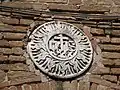Das IHS-Symbol des Bernhardin von Siena an der Außenseite des Stadttores
