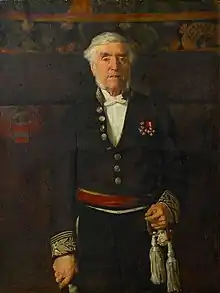  Portraitgemälde. Das Bild zeigt Leopold Vander Kelen als älteren, weißhaarigen Mann mit Backenbart. Er steht aufrecht und schaut den Betrachter an. Er trägt eine dunkle Uniform mit zwei Orden an der Brust. Seine rechte Hand stützt sich auf einen Stock, die linke ruht am Heft eines Schwertes. Der Hintergrund ist dunkel, man erkennt aber ein Wappen, den Schriftzug „LEUVEN“ sowie ein florales Muster am oberen Bildrand.