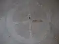 An der Decke des Kapellenraums ist in der Mitte der Dachkuppel ein von einem Kreisring umgebenes Kreuzsymbol angemalt.