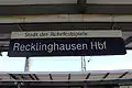 Bahnhofsschild mit Zusatzhinweis