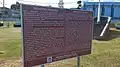 Schild, das die geschichtliche Bedeutung von Rémy Ollier erklärt, Mahébourg.