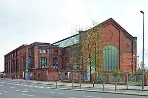 Straßenseite mit den erhaltenen Teilen des denkmalgeschützten Kraftwerkes von 1907, Maschinenhalle rechts und Betriebsgebäude links (2011)
