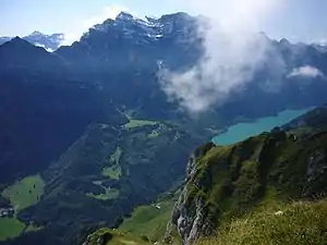 Klöntalersee gesehen aus der Südflanke des Wiggis mit der sichtbaren ursprünglichen natürlichen Stauung