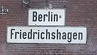 Durch Zeilen­umbruch aus Einfach­bindestrich abgeleiteter Doppel­bindestrich; der Bahn­hofs­name und gleich­namige Ortsteil schreibt sich „Berlin‑Friedrichshagen“
