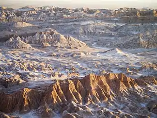 Die Cordillera de la Sal (wörtlich: Salzgebirge) ist eine Karstlandschaft aus rotem Sedimentgestein und weißem Evaporit geformt. Kochsalz und Gips lassen sie in ihren zentralen Bereichen fast wie eine Schneelandschaft aussehen.