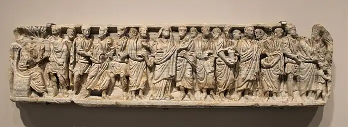 Teil eines Marmorsarkophags, 4. Jh. Im Gegensatz zur üblichen Darstellung der Zeit sind die Figuren hier nicht durch Bäume getrennt. Das Fragment wurde bei einem Narbonner Haus wieder verwertet.
