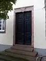 Eingang zum Wohnhaus mit Wappen über dem Sturz