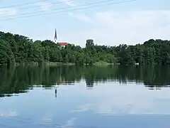 Schloßsee vom Park von Schloss Hartmannsberg, im Hintergrund die Kirche von Stephanskirchen