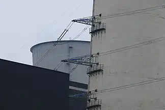 Am Schornstein befestigte Hochspannungsleitungen