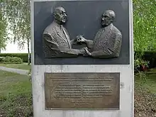 Skulptur „Konrad Adenauer und Charles de Gaulle“ von Chantaldela Chauvinière-Riant, 2002, zur Erinnerung an die Vertragsunterzeichnung, Tiergartenstraße 35, Berlin-Tiergarten. Der untere Teil des Denkmals enthält ein Zitat aus der gemeinsamen Erklärung in Französisch und Deutsch.