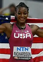 100-Meter-Siegerin Sha’Carri Richardson präsentiert sich mit Landesfahne.