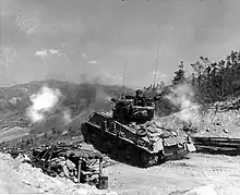 Ein Sherman-Panzer beschießt eine feindliche Bunkerstellung (Mai 1952)