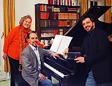 Siegrid Ernst steht mit Maximiliano de Brito und Renato Mismetti an einem Flügel, 2014