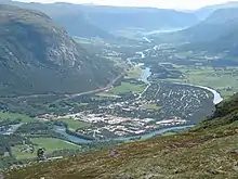 Luftbild eines sich durch ein Tal ziehenden Flusses mit einer Ortschaft an seinem Ufer