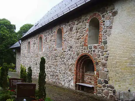 Nordseite mit romanischen Fenstern,und teilweise vermauertem ehemaligem Portal