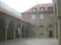 Arkadenhof, links: Arkadengang, Mitte: Pfarrhaus mit Blendarkaden, rechts: Hauptportal.