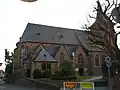 Der Chor der Kirche mit Sakristei im Vordergrund. Rechts daneben ist die Seitenpforte mit den Gedenktafeln zu erkennen