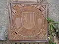 Wappen auf einem Kanaldeckel auf dem Tännichtweg in Hellerau