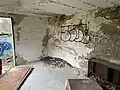 Blick von der anderen Seite der unterkunft. An der Wand mit dem Graffiti waren Stockbetten angebracht