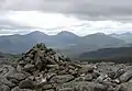 Der Gipfelcairn des Cona’ Mheall, im Hintergrund die Fannichs mit dem Sgùrr Mòr (links) und dem Sgùrr nan Clach Geala (rechts)