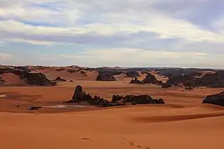 Östliche Abhänge des Tassili Tadrart in Dünen auslaufend