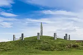 Foto eines hohen dünnen Steinblocks, der auf einer Anhöhe steht