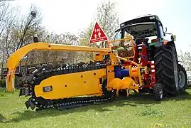 Grabenfräse als Anbaugerät eines Traktors: Sie wird durch eine Kardanwelle angetrieben, die mit der Zapfwelle des Traktors verbunden ist.