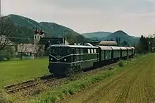 Der erste Triestingtalexpress gezogen von der 2050.02 am 1. Mai 2005 in Thenneberg. Im Hintergrund ist die Kirche zu sehen.