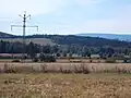 Alte, heute mit Drehstrom betriebene Bahnstrom-Freileitung in Schlesien: Zuerst verwendeter Masttyp mit zwei …