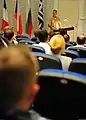 U.S. Navy Capt. Bradley D. Martin spricht vor einer Großübung zum Publikum bei der NMIOTC.